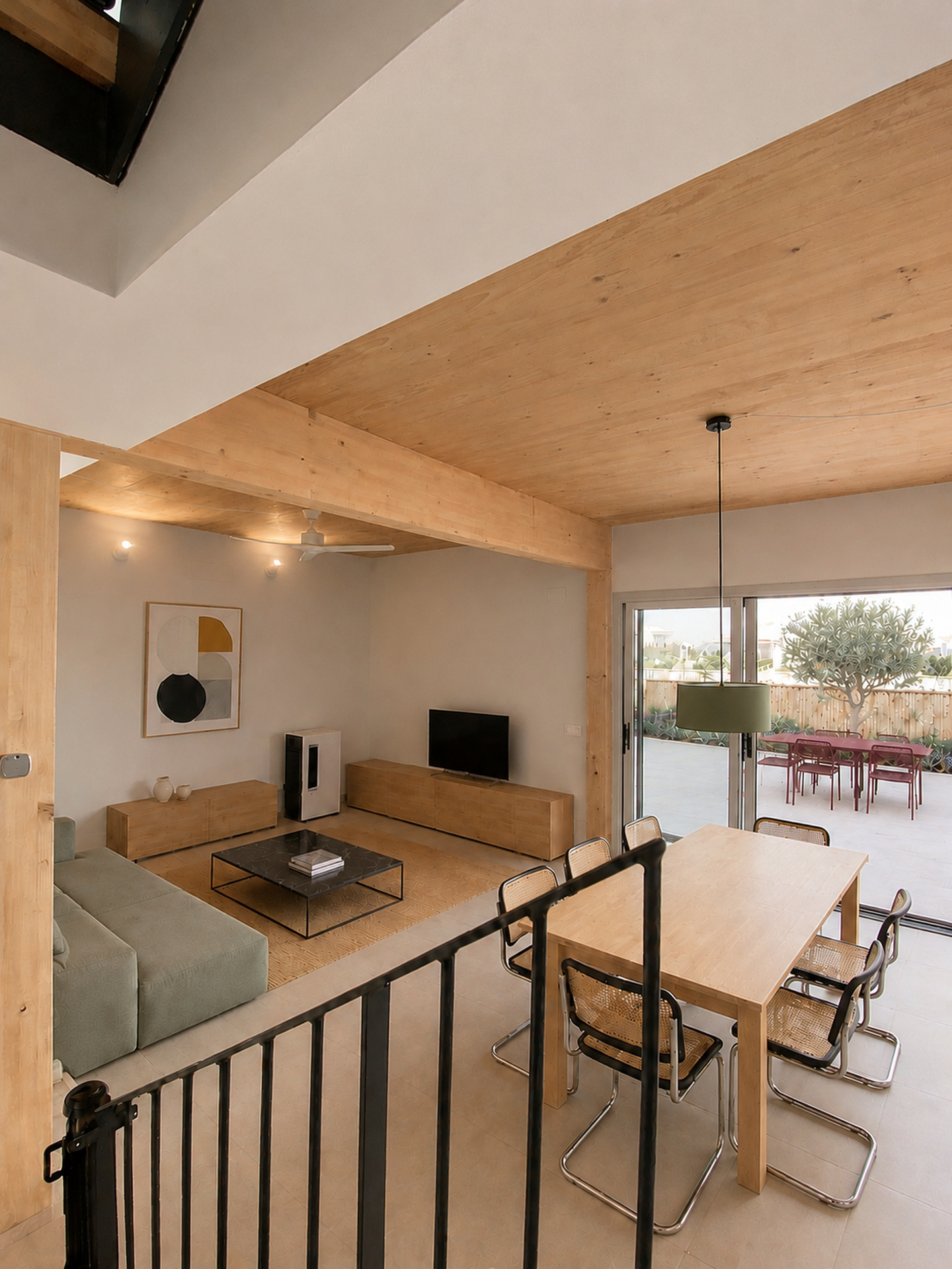 Estar comedor con gran apertura acristalada de aluminio hacia el exterior en Vilanova i la Geltrú
